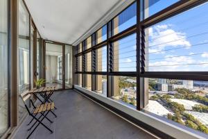 una habitación vacía con ventanas, mesas y sillas en Lovely 2 bedroom APT in centre of Sydney Olympic Park en Sídney