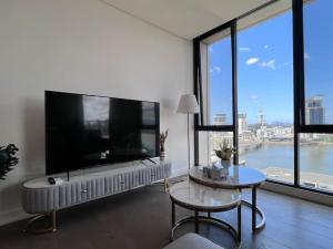 uma sala de estar com uma grande televisão de ecrã plano em Your Luxury Weekend Getaway in Wentworth Point em Sydney