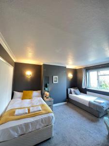 a bedroom with a large bed and a couch at Airport Garden Rooms in Feltham