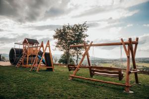a playground with two swings and a slide at Górskie Tarasy in Rabka