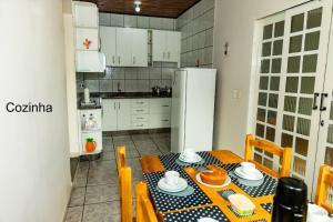 uma cozinha com uma mesa e cadeiras e um frigorífico em Casa na Fronteira em Foz do Iguaçu