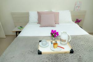 a bed with a tray with food and flowers on it at Casa na Fronteira in Foz do Iguaçu