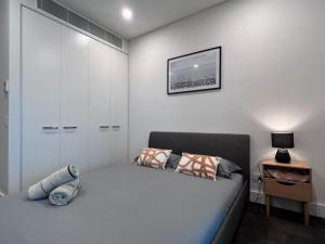 a white bedroom with a bed and a table at High Level Fabulous View 4Beds APT in Olympic Park in Sydney