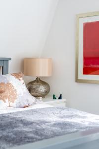 a bedroom with a bed with a lamp on it at The Secret, Stylish & Spacious En Suite in Blandford Forum, Dorset in Blandford Forum