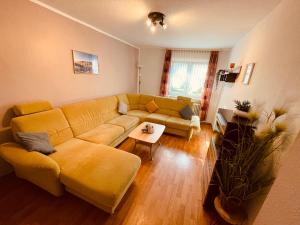 sala de estar con sofá amarillo y mesa en Moselferienhaus Porten, en Ellenz-Poltersdorf