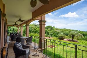 balkon z krzesłami i widokiem na dziedziniec w obiekcie Jobo 1 Luxury Apartment - Reserva Conchal w mieście Playa Conchal