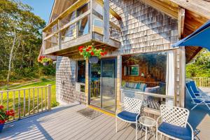 a house with a deck with chairs and a balcony at Lobsterville Landing in Lobsterville