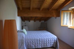 een slaapkamer met een bed en een houten plafond bij BAITA BELLAVISTA Affiliato Best-Incoming in Adrara San Rocco