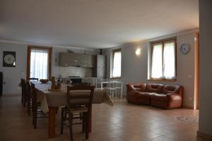 een keuken en een woonkamer met een tafel en een bank bij BAITA BELLAVISTA Affiliato Best-Incoming in Adrara San Rocco