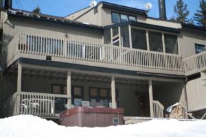 a large house with a porch and a balcony at 2 bdrm Tremblant Haven-pets & spa-walk/ski to hill in Mont-Tremblant