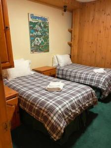 two beds sitting next to each other in a room at 2 bdrm Tremblant Haven-pets & spa-walk/ski to hill in Mont-Tremblant