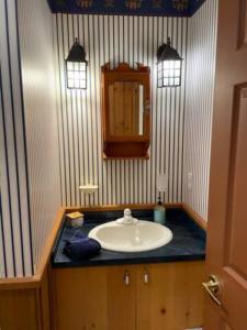 a bathroom with a sink and a mirror at 2 bdrm Tremblant Haven-pets & spa-walk/ski to hill in Mont-Tremblant