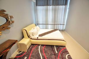a small bedroom with a bed and a window at Skyview Apartments in Gaborone