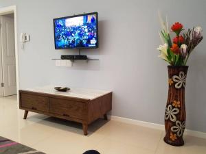 a living room with a tv and a vase of flowers at Skyview Apartments in Gaborone