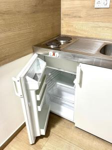eine Küche mit einem offenen Kühlschrank und einer Spüle in der Unterkunft Apartment mit 3 Betten, Küche & Bad in Kassel in Kassel