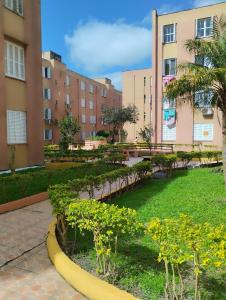 park z drzewami i roślinami przed budynkami w obiekcie Apartamento 2 quartos w mieście Pelotas