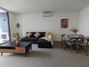 a living room with a couch and a table at High Level Luxury APT in Wentworth Point in Sydney