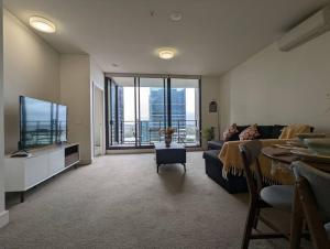 a living room with a couch and a flat screen tv at High Level Luxury APT in Wentworth Point in Sydney
