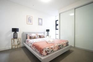 a white bedroom with a bed and a window at High Level Luxury APT in Wentworth Point in Sydney