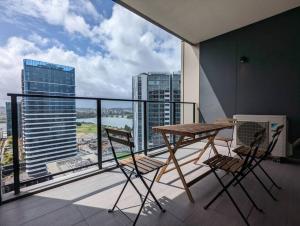 a balcony with a table and chairs on a balcony at High Level Luxury APT in Wentworth Point in Sydney