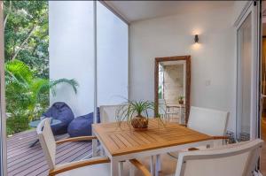 a dining room with a wooden table and chairs at NEW! Boho chic condo, Aldea Zama in Tulum