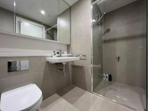 uma casa de banho com um WC, um lavatório e um chuveiro em Lovely 2 bedroom APT in centre of Olympic Park em Sydney