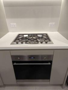 cocina blanca con fogones en Lovely 2 bedroom APT in centre of Olympic Park, en Sídney