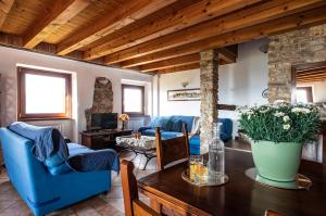a living room with blue chairs and a table at Rustico Bertel in San Zeno di Montagna