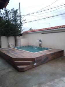 a swimming pool with a wooden deck around it at Casa espaçosa com Piscina e Churrasqueira 2 dorm in Guarujá