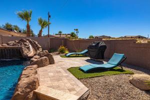 a backyard with a pool with two blue chairs at Beach Happy-Lake Close-Private Waterpark Oasis -sleeps 14 in Lake Havasu City
