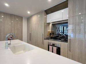 a kitchen with a sink and a stove at Luxury 2 bedroom APT in Wentworth Point in Sydney