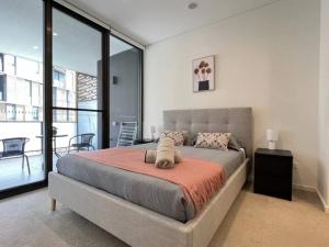 a bedroom with a large bed and a balcony at Luxury 2 bedroom APT in Wentworth Point in Sydney