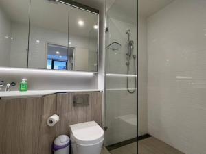 a bathroom with a shower and a toilet and a mirror at Luxury 2 bedroom APT in Wentworth Point in Sydney