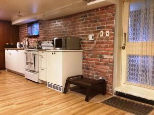 a kitchen with a brick wall and a stool at Maria Montreal in Montreal