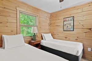 two beds in a room with wooden walls at Moonbeams & Fireflies in Chestertown +38 photos