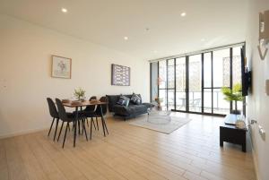 uma sala de estar com uma mesa e um sofá em Stunning 2 bedroom APT in Wentworth point em Sidney