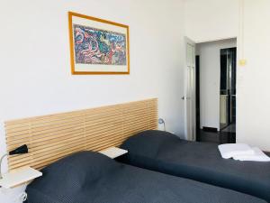 Zimmer mit 2 Betten und einem Bild an der Wand in der Unterkunft Maison vigneronne à Mèze in Mèze