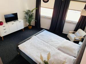 a bedroom with a bed and a tv and a chair at Ferienwohnung Edge-Inn in Süpplingen
