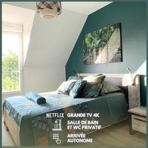 een slaapkamer met een bed met een blauwe muur bij Chambre Evasion - SDB WC Privatif - Entrée autonome - Grande TV NETFLIX in Compiègne