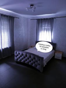 Un dormitorio con una cama con un cartel. en Cataleya Caffee en Rădăuţi