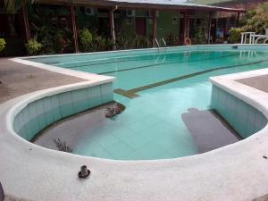 una gran piscina con azulejos azules alrededor. en Hotel Santa Helena en Leticia