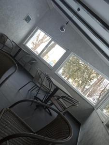 um escritório com duas janelas e uma cadeira num quarto em Cataleya Caffee em Rădăuţi