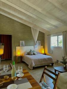 a bedroom with a bed and a table with wine glasses at La Serena Suites Aparthotel in La Paloma