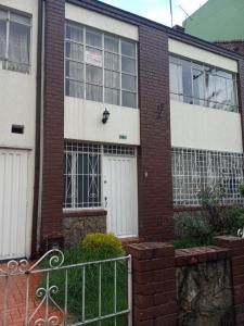 a brick building with two white doors and a fence at Casa en Bogotá ubicada en zona central in Bogotá