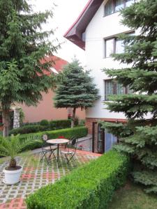 a courtyard of a house with a table and trees at Csaki Vendeghaz in Sovata