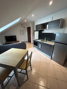 a kitchen and living room with a table and a couch at Hyper centre petit diamérisma in Charleville-Mézières