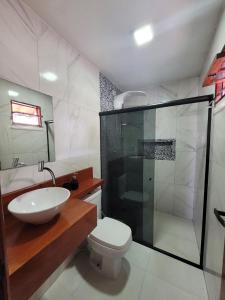 y baño con lavabo, aseo y ducha. en Casa Akua, en São Miguel dos Milagres