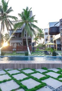 KokrobiteSerenity Residences & Spa - Kokrobite Beach的一座棕榈树度假村,位于一座建筑前