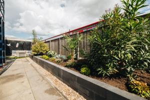 a garden with a fence and plants and a sidewalk at Duikresort Sub Ocean Hotel in Oud-Vossemeer
