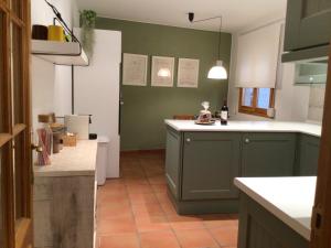 a kitchen with green cabinets and a white counter top at Lo corralet in Torre del Compte